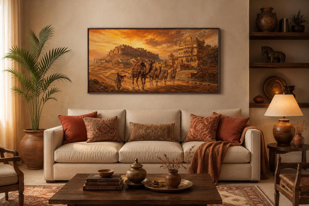 Indian camel caravan painting in a desert landscape at sunset, hung above a beige sofa.