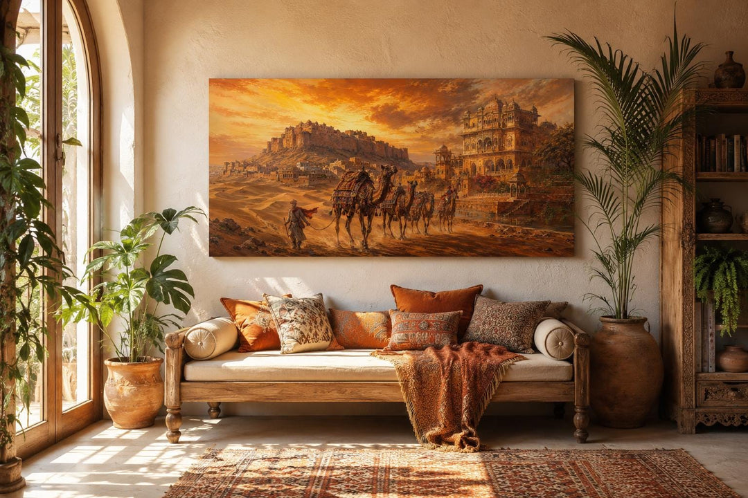 Indian camel caravan painting on a canvas print hanging above a sofa in a warm, bohemian room.