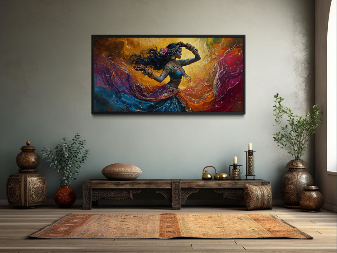 A horizontal canvas print of a colorful Indian dancer in motion, framed on a neutral wall.