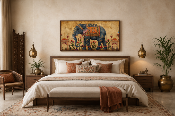 Framed canvas wall art of a decorated blue Indian elephant hanging above a bed in a neutral room.