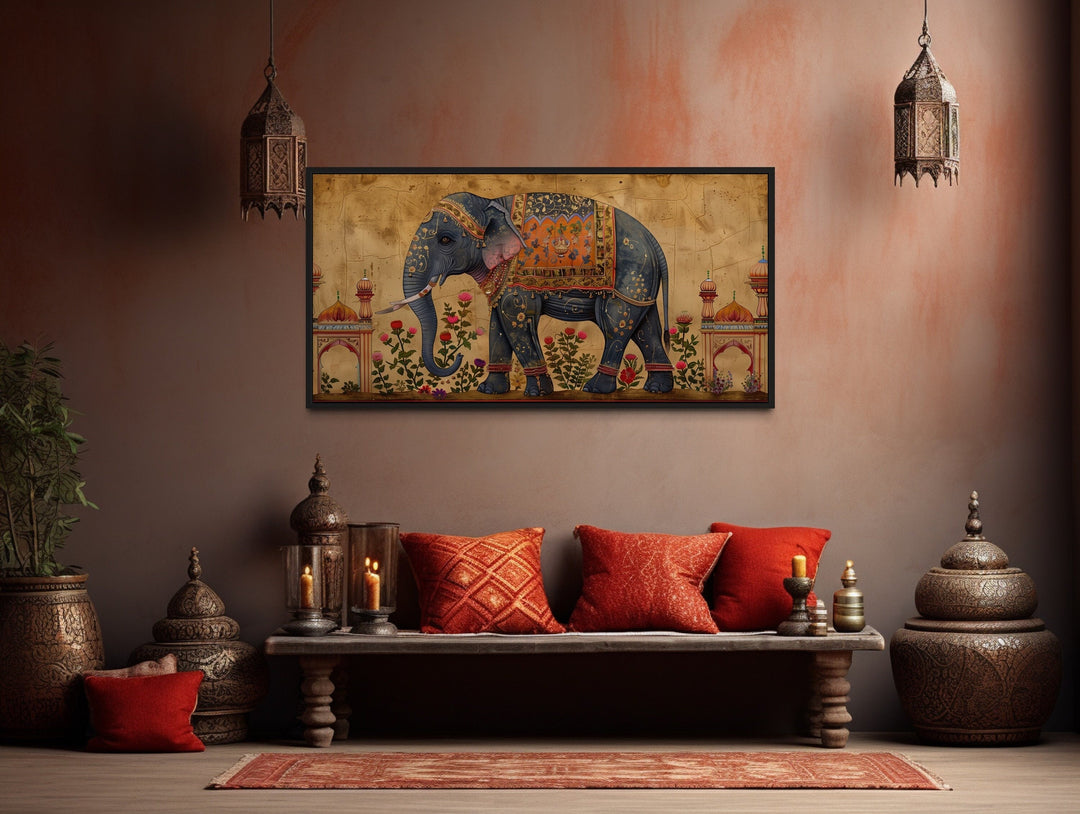 Framed canvas wall art of a decorated Indian elephant in a traditional, warm-toned room setting.