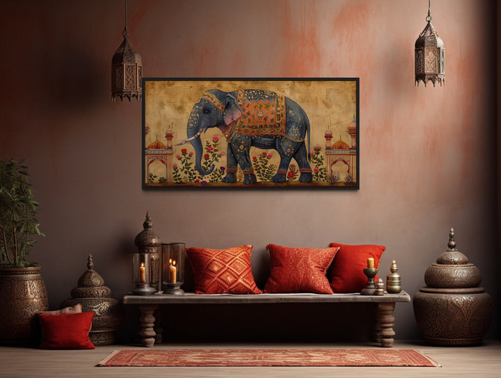 Framed canvas wall art of a decorated Indian elephant in a traditional, warm-toned room setting.