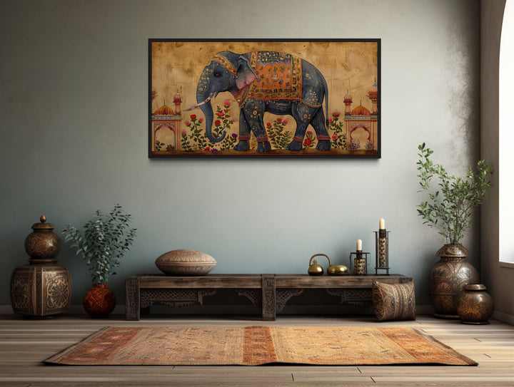 Framed canvas wall art of a decorated Indian elephant in a traditional room setting.