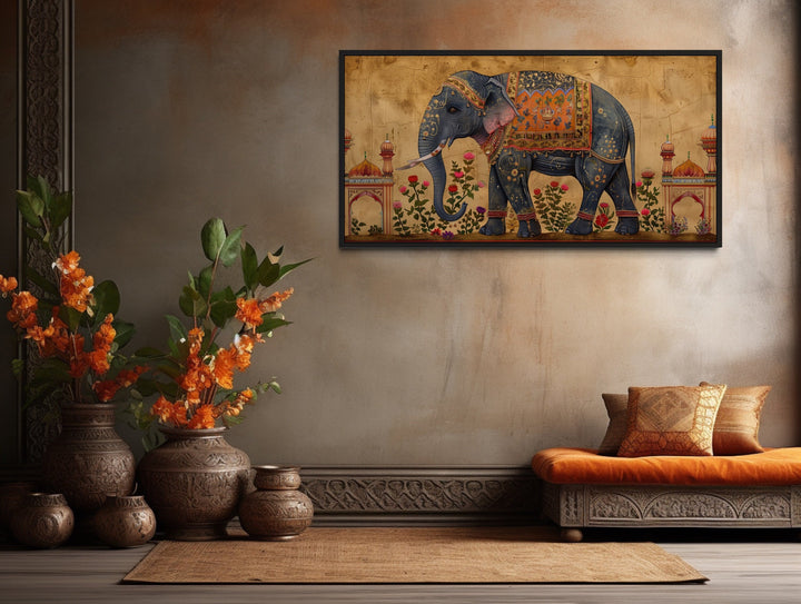 Framed canvas wall art of a decorated Indian elephant in a traditional room with vases and a bench.