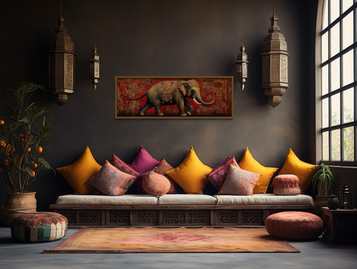Panoramic framed canvas wall art of a traditional Indian elephant on a red patterned background.