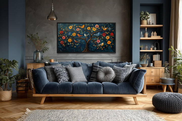 Madhubani Tree of Life canvas wall art featuring colorful birds and flowers above a blue sofa.