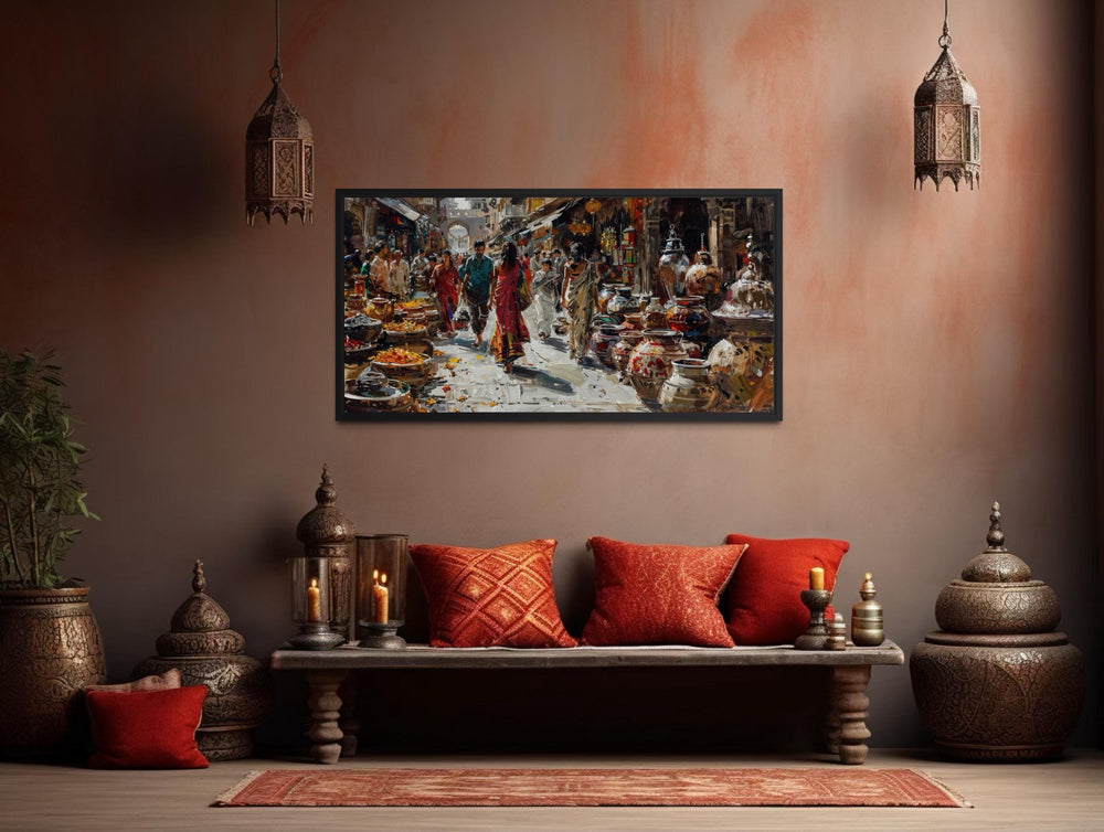 A framed canvas painting of a vibrant Indian bazaar scene hangs in a warm, culturally styled room.