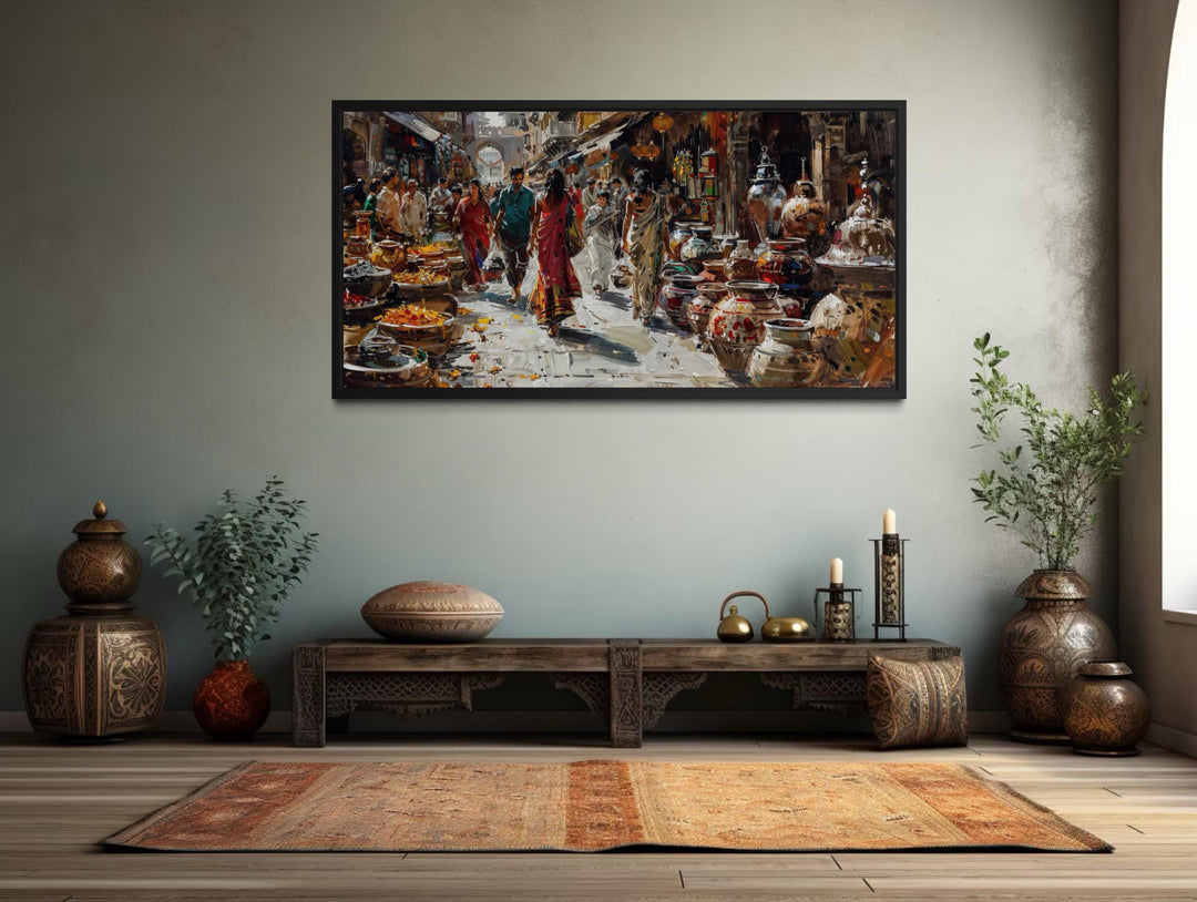 Framed canvas painting of a vibrant Indian bazaar scene displayed in a culturally styled room.