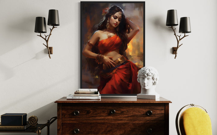 Framed canvas wall art of an Indian woman in a red sari dancing, displayed above a wooden dresser.