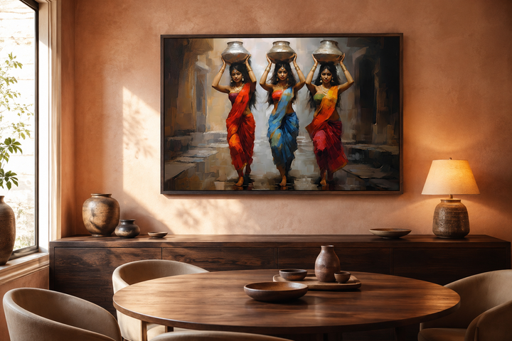Framed canvas wall art of three Indian women in colorful saris carrying water pots on their heads.