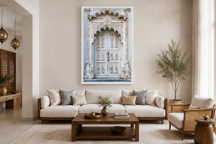 White and grey framed canvas wall art of an intricate Indian door above a modern sofa.