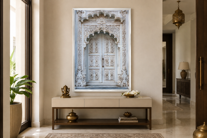 White and grey framed canvas wall art of an intricate traditional Indian door in a modern entryway.