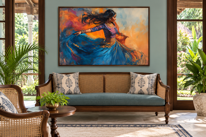 Indian Woman Dancing Framed Canvas Wall Art in a walnut frame above a blue and cane sofa.