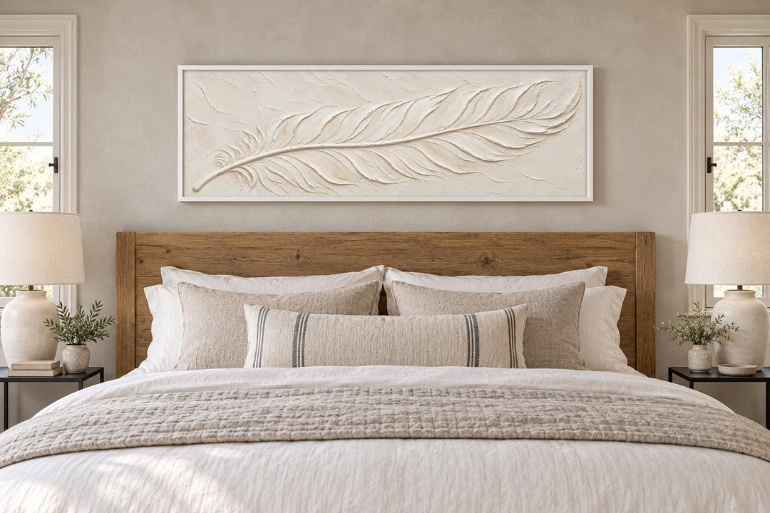 Ivory feather plaster-effect long canvas wall art centered above a wooden bed with neutral bedding.