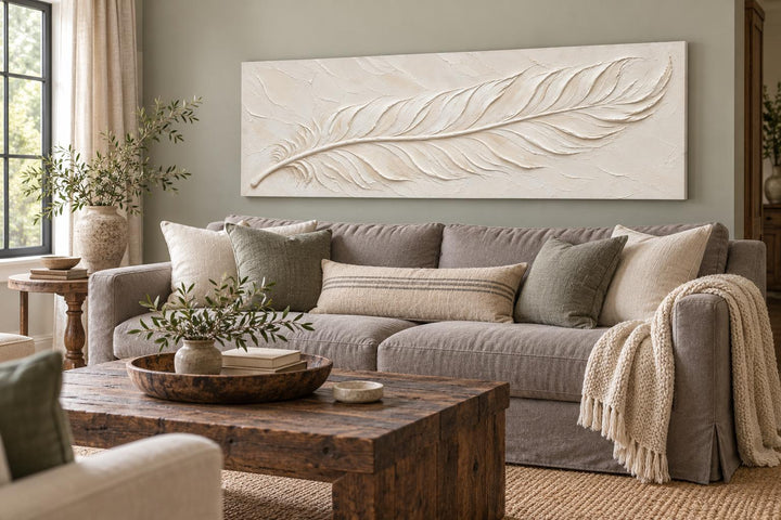 Ivory Feather long narrow canvas wall art with a cream plaster effect above a neutral sofa.