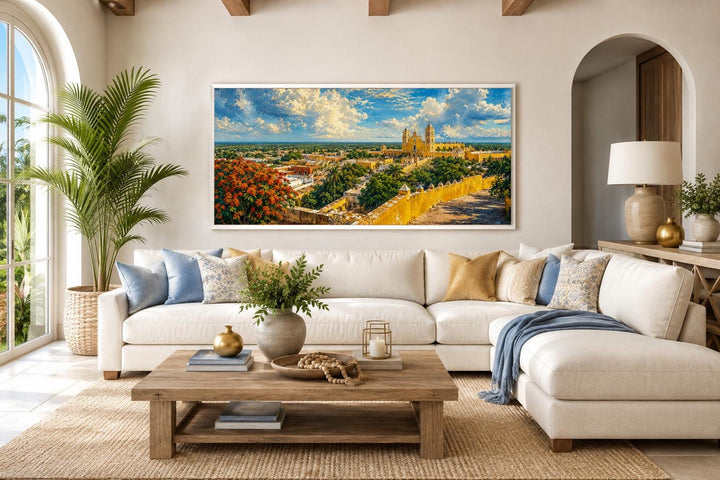 Izamal Cityscape canvas wall art featuring yellow colonial buildings above a white sectional sofa.