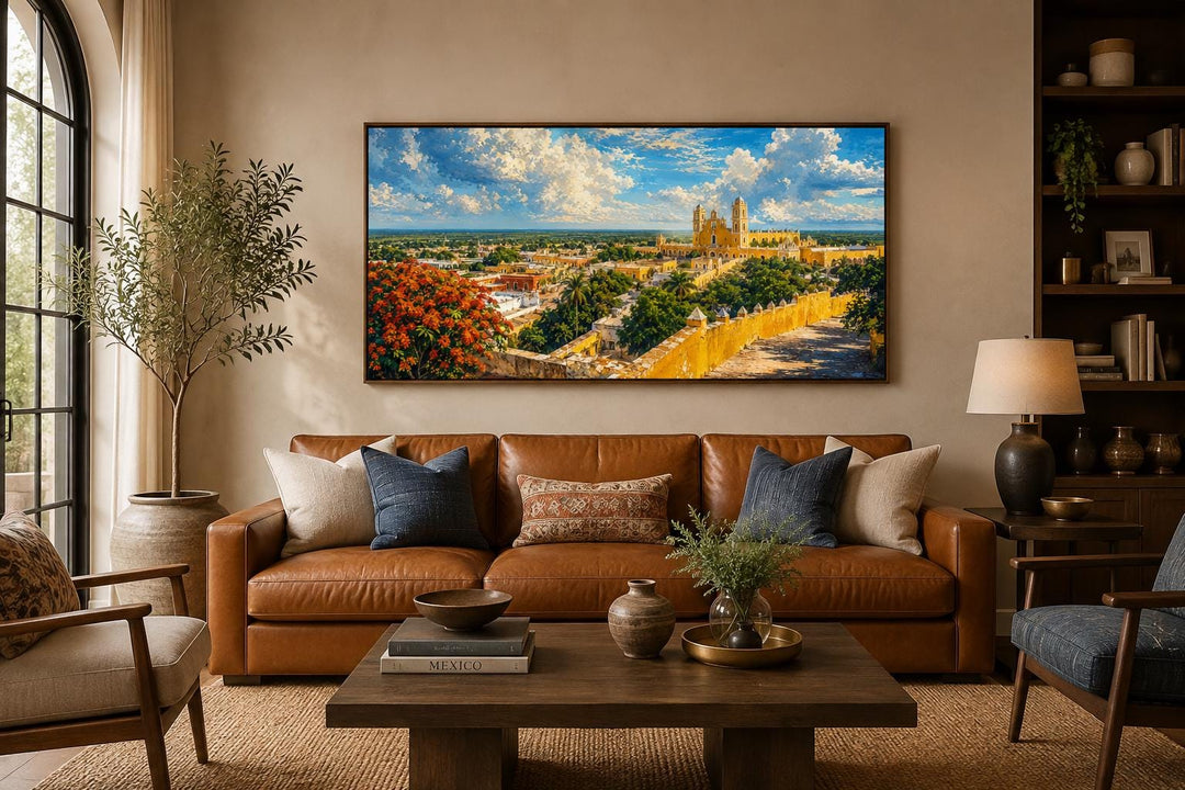 Izamal Cityscape canvas wall art featuring yellow colonial buildings above a brown leather sofa.