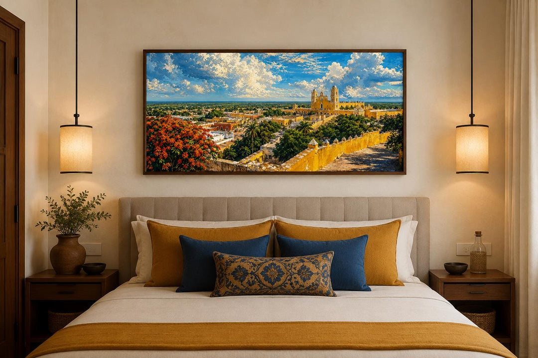 Izamal Cityscape canvas wall art featuring yellow colonial buildings above a bed in a bedroom.