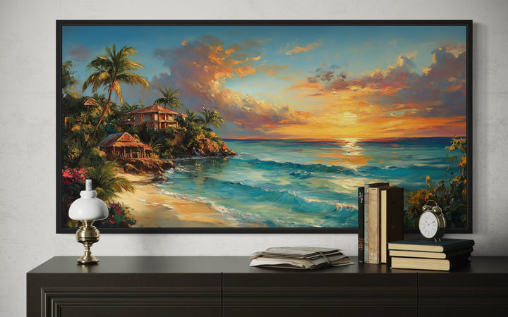 Jamaican sunset beach framed canvas wall art above a dark sideboard with books and a lamp.