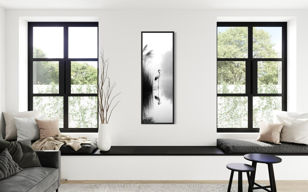 Vertical narrow canvas print of a Japanese crane in black and white zen style on a white wall.
