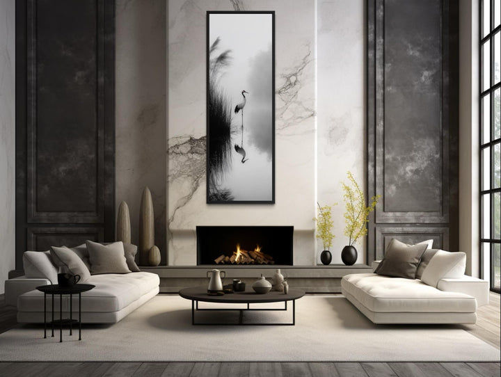 Vertical narrow canvas print of a Japanese crane in black and white zen style above a fireplace.
