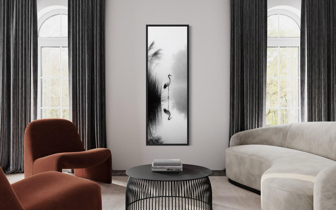 Vertical narrow canvas print of a Japanese crane in black and white zen style on a living room wall.