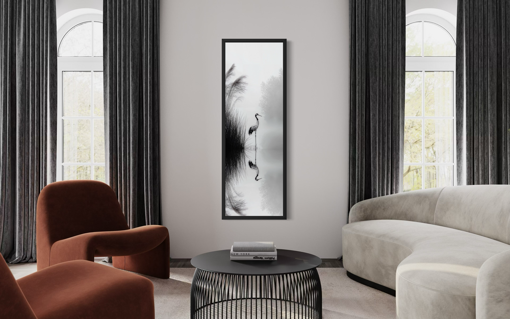 Tall narrow black and white Japanese crane wall art in a modern living room with zen decor.