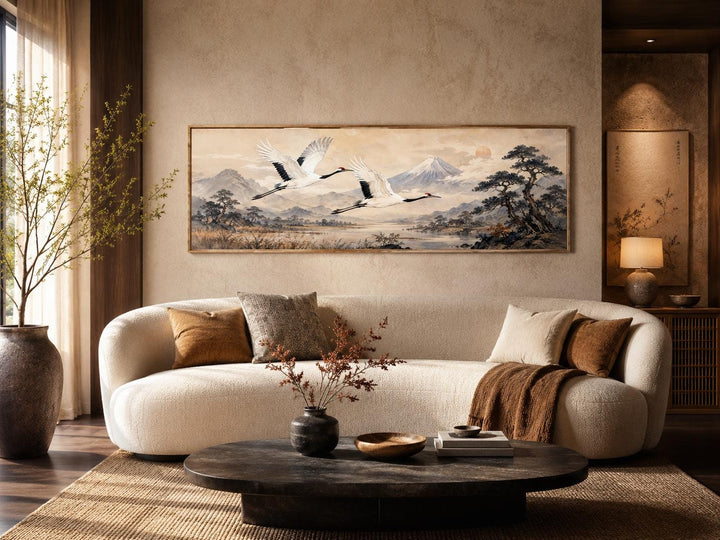 Japanese watercolor canvas of red-crowned cranes flying over misty mountains in a zen living room.