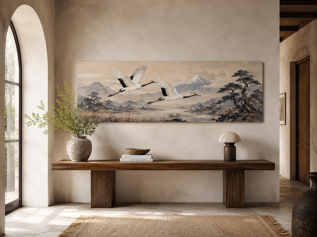 Japanese watercolor canvas of red-crowned cranes flying over misty mountains above a wooden bench.