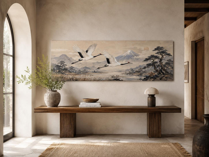 Japanese watercolor canvas of red-crowned cranes flying over misty mountains above a wooden bench.