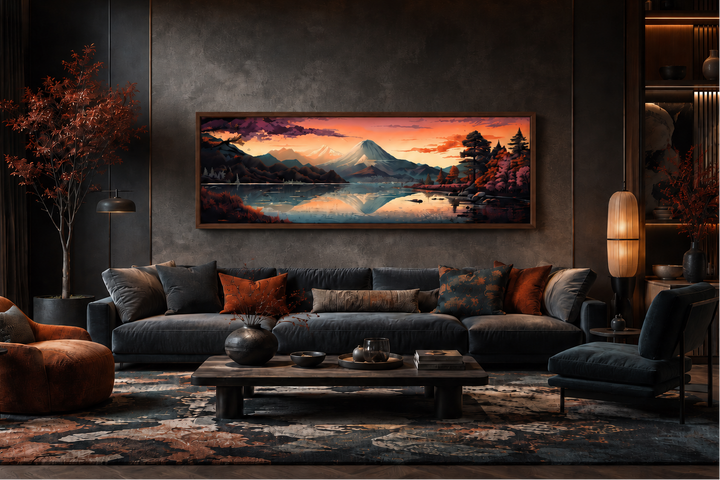 Horizontal framed canvas of Mt. Fuji and Lake Kawaguchiko at sunset above a dark velvet sofa.