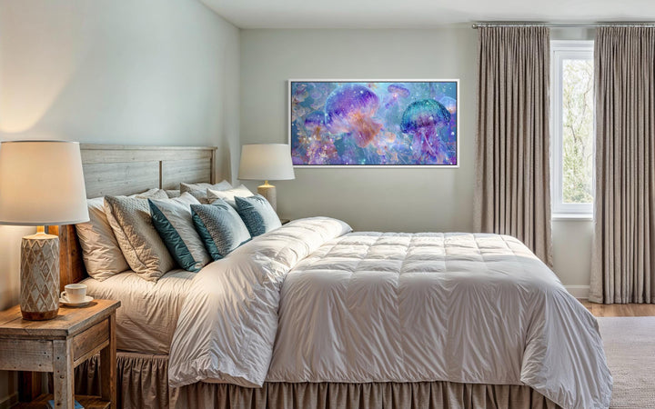A horizontal canvas of colorful jellyfish in purple and blue tones hangs above a neutral bed.