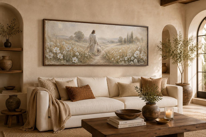 Jesus and lamb in a wildflower field canvas print hanging above a cream sofa in a farmhouse room.