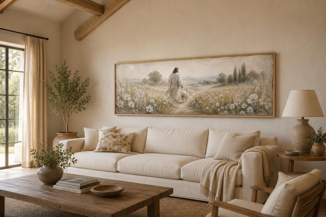 Jesus and lamb in a wildflower field canvas print hanging above a neutral sofa in a living room.