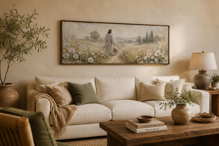 Jesus and lamb in a wildflower field canvas print hanging above a cream sofa in a living room.