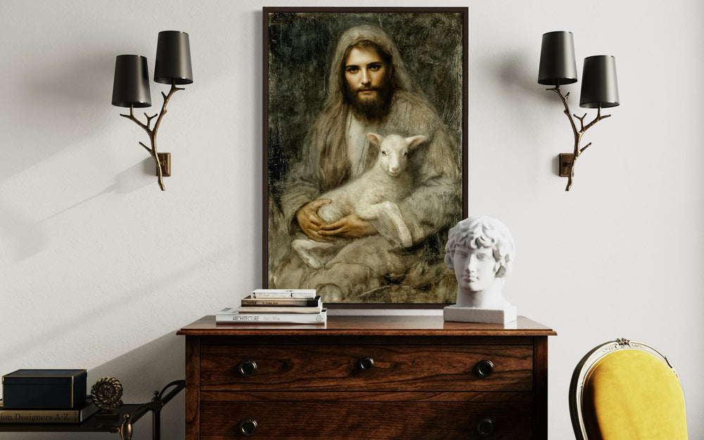 Framed canvas wall art of Jesus holding a lamb, displayed above a wooden dresser in a classic room.