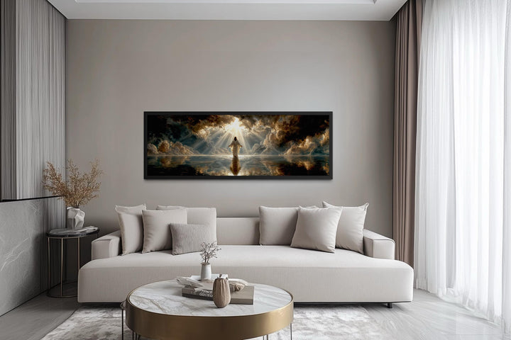 Panoramic canvas print of Jesus walking on water displayed above a modern sofa in a living room.