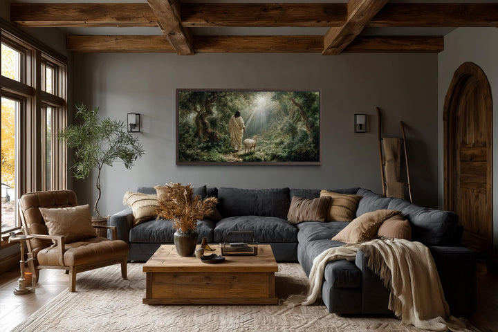 Horizontal canvas art of Jesus as the Good Shepherd in a forest, hung in a rustic living room.