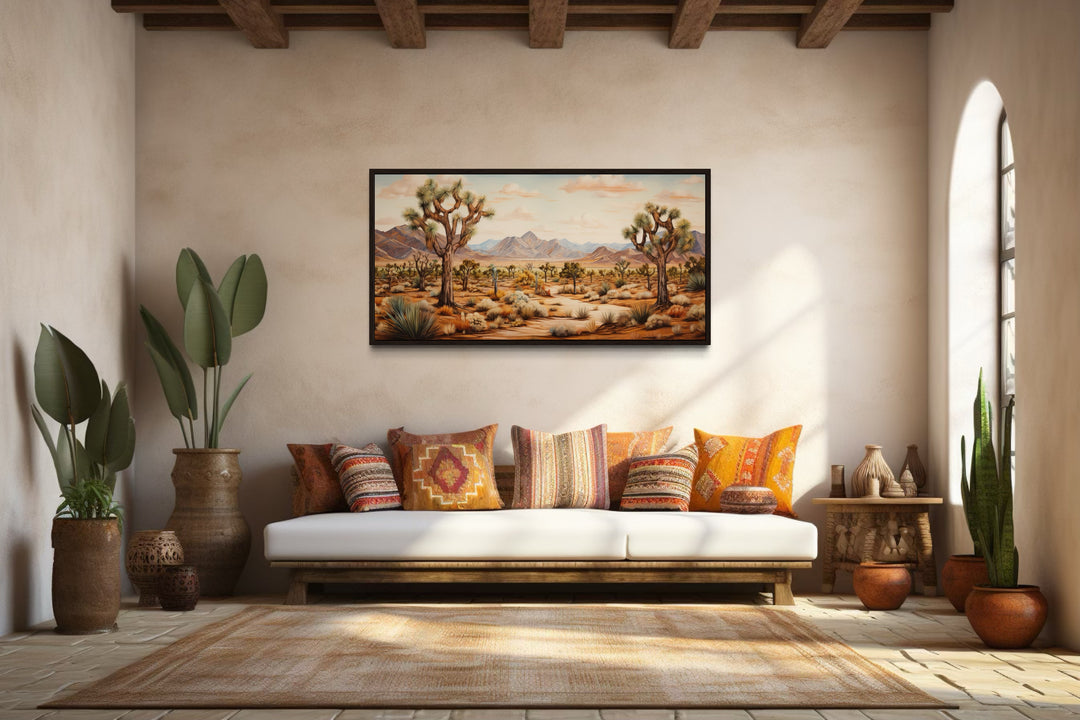 Framed Joshua tree desert landscape painting on a wall above a white sofa with colorful pillows.