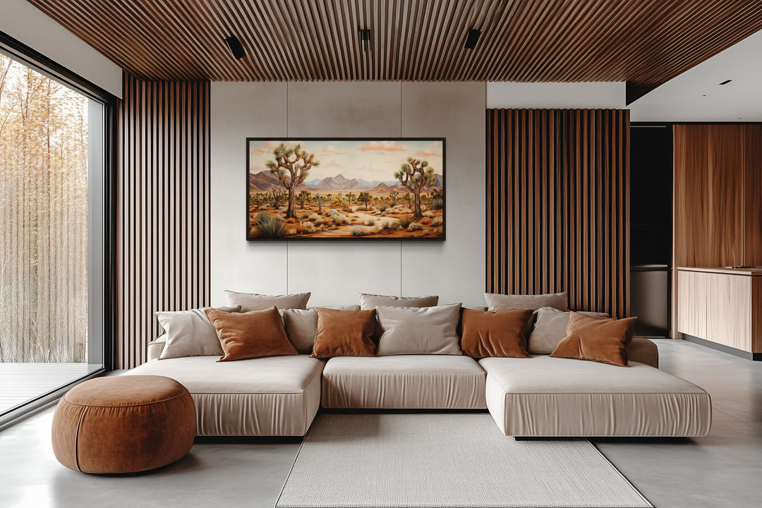 Framed Joshua tree desert landscape painting on a wall above a modern sectional sofa.