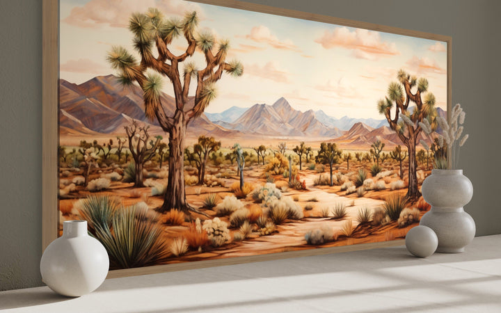 Framed canvas painting of a Joshua tree desert landscape with mountains in warm earth tones.