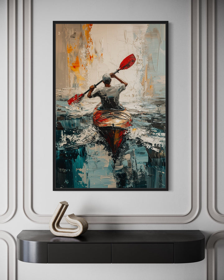 Abstract framed canvas wall art of a kayaker with a red paddle on a lake, hung above a black console.