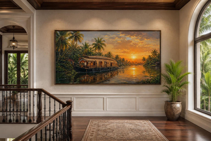 Kerala backwaters houseboat painting at sunset on a living room wall above wainscoting.