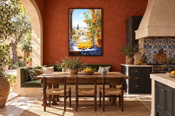 Framed Mediterranean window view painting with oranges on a terracotta kitchen wall.