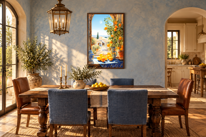 Framed Mediterranean window view painting with oranges hanging in a rustic blue dining room.