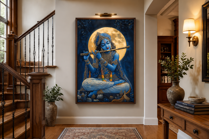Framed canvas art of Blue Krishna playing a flute under a full moon in a traditional home hallway.