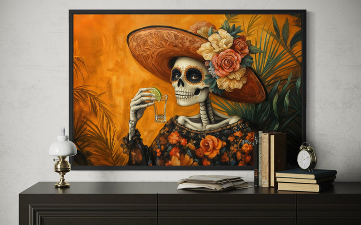 La Calavera Catrina Drinking Tequila Mexican canvas wall art displayed in a black frame.