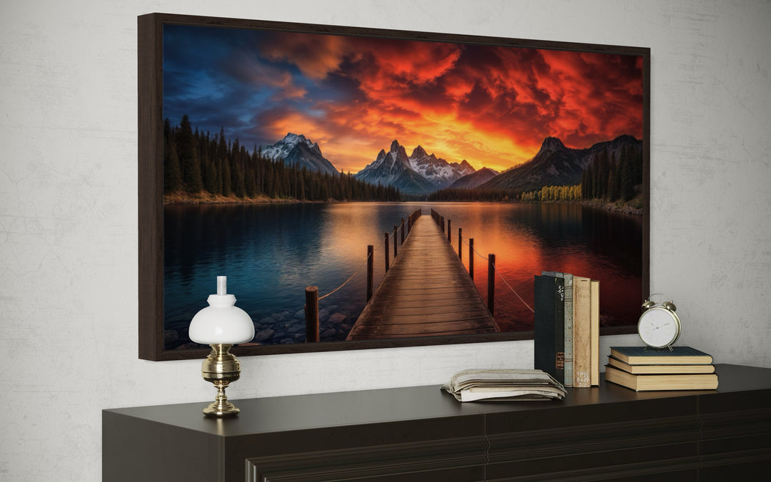 Framed canvas wall art of a lake and fishing pier at sunset with mountains and a vibrant sky.