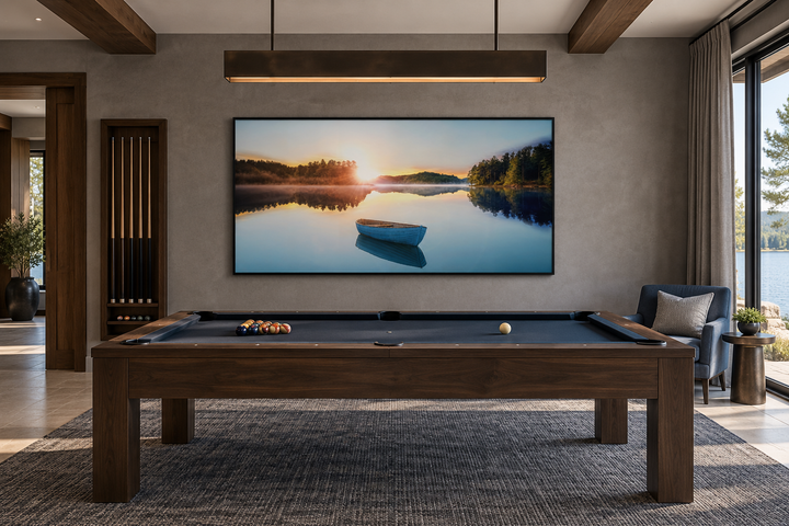 Serene Lake Sunrise With Boat canvas wall art in a black frame above a pool table in a modern room.