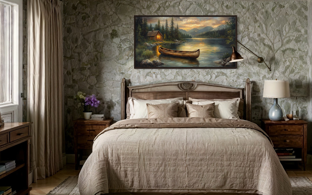 Rustic canvas wall art of a wooden canoe on a serene lake with a cabin and mountains at sunset.